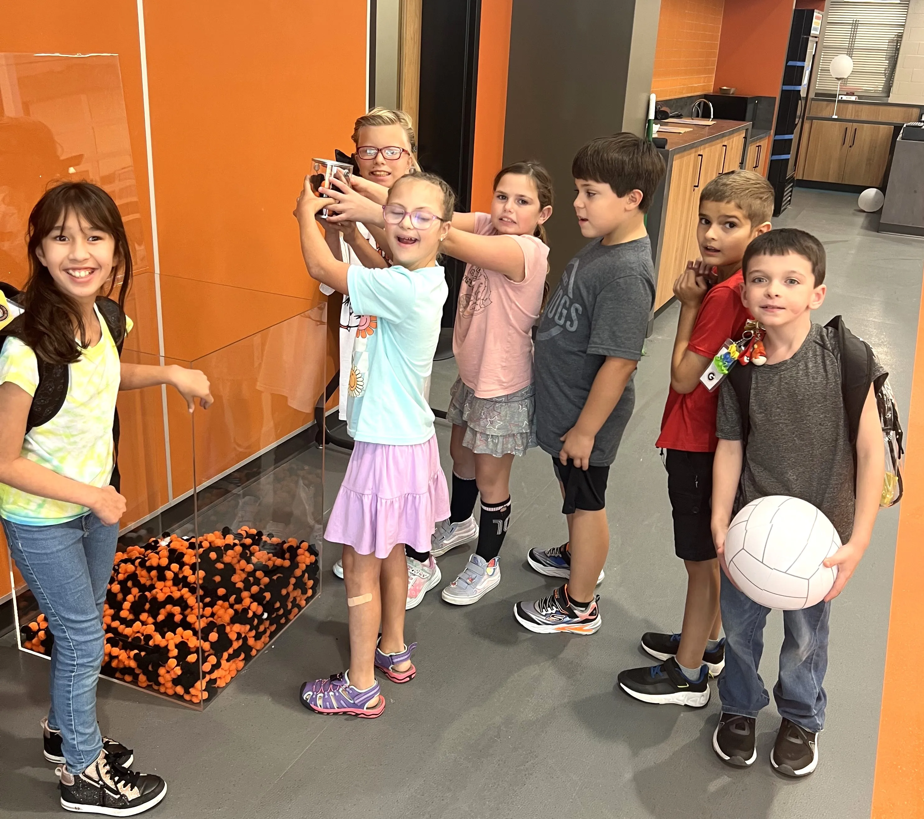 Students dumping PBIS poms into school-wide bin